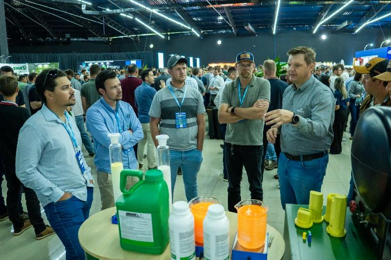 Expositor de Agrofertil explicando sobre productos agrícolas a un grupo de asistentes en el Simposio de Maíz.