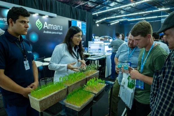Expositora de Amaru explica análisis de plántulas a productores en el Simposio de Maíz.