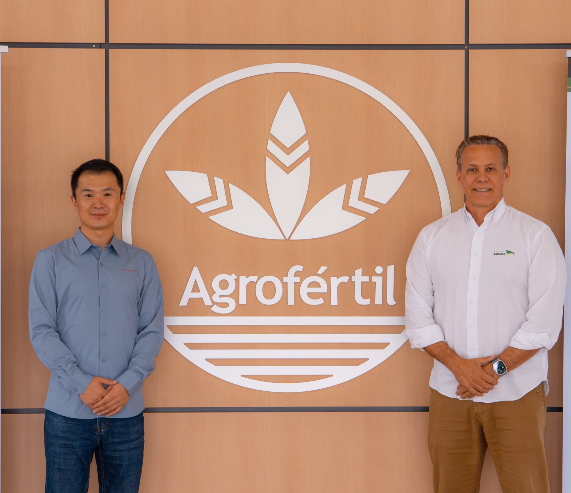 Representantes de KingAgroot y Grupo Sarabia frente al emblema de Agrofértil
